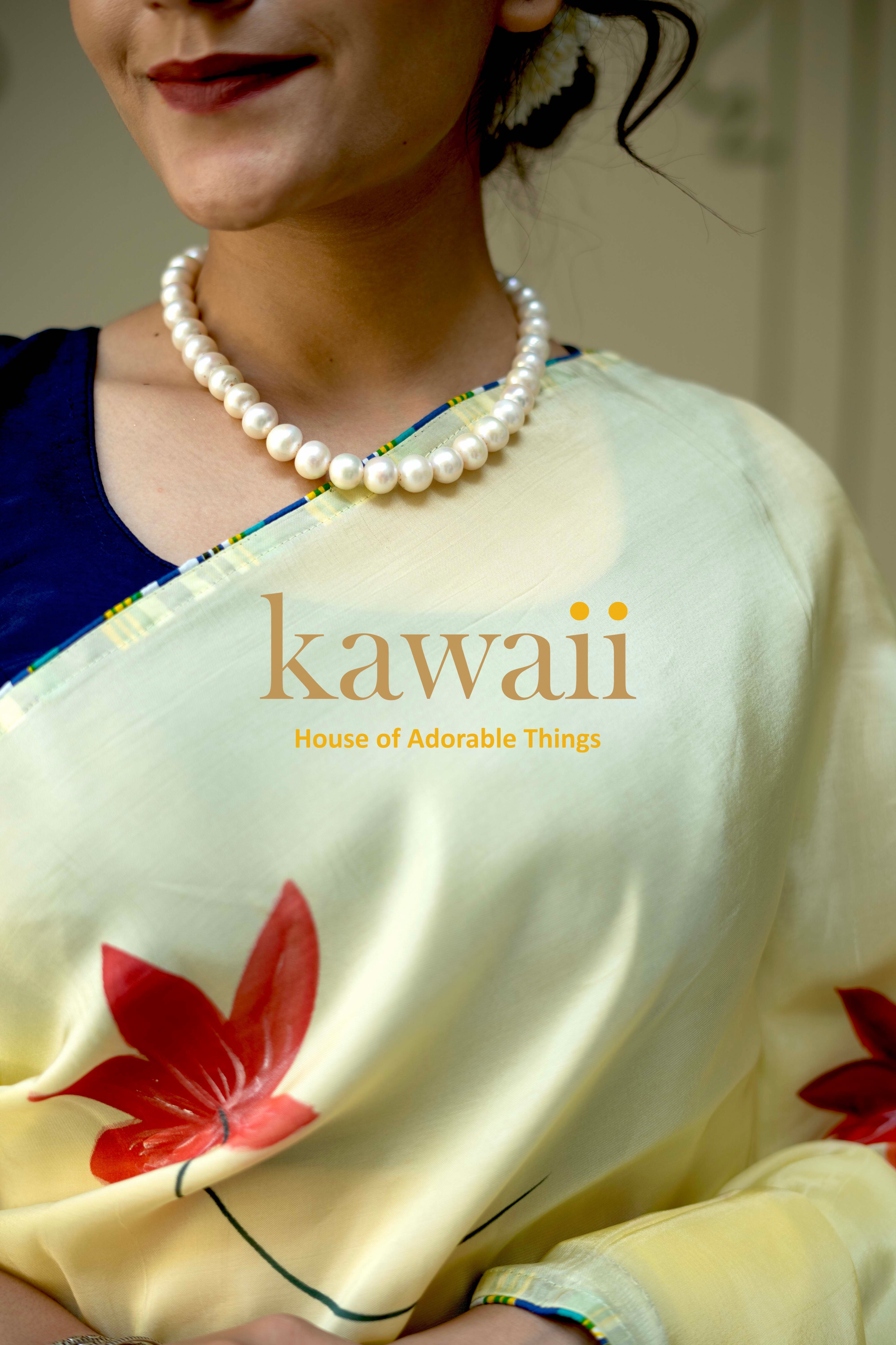 Kawaii cream pichwai saree with red floral design worn with pearl necklace