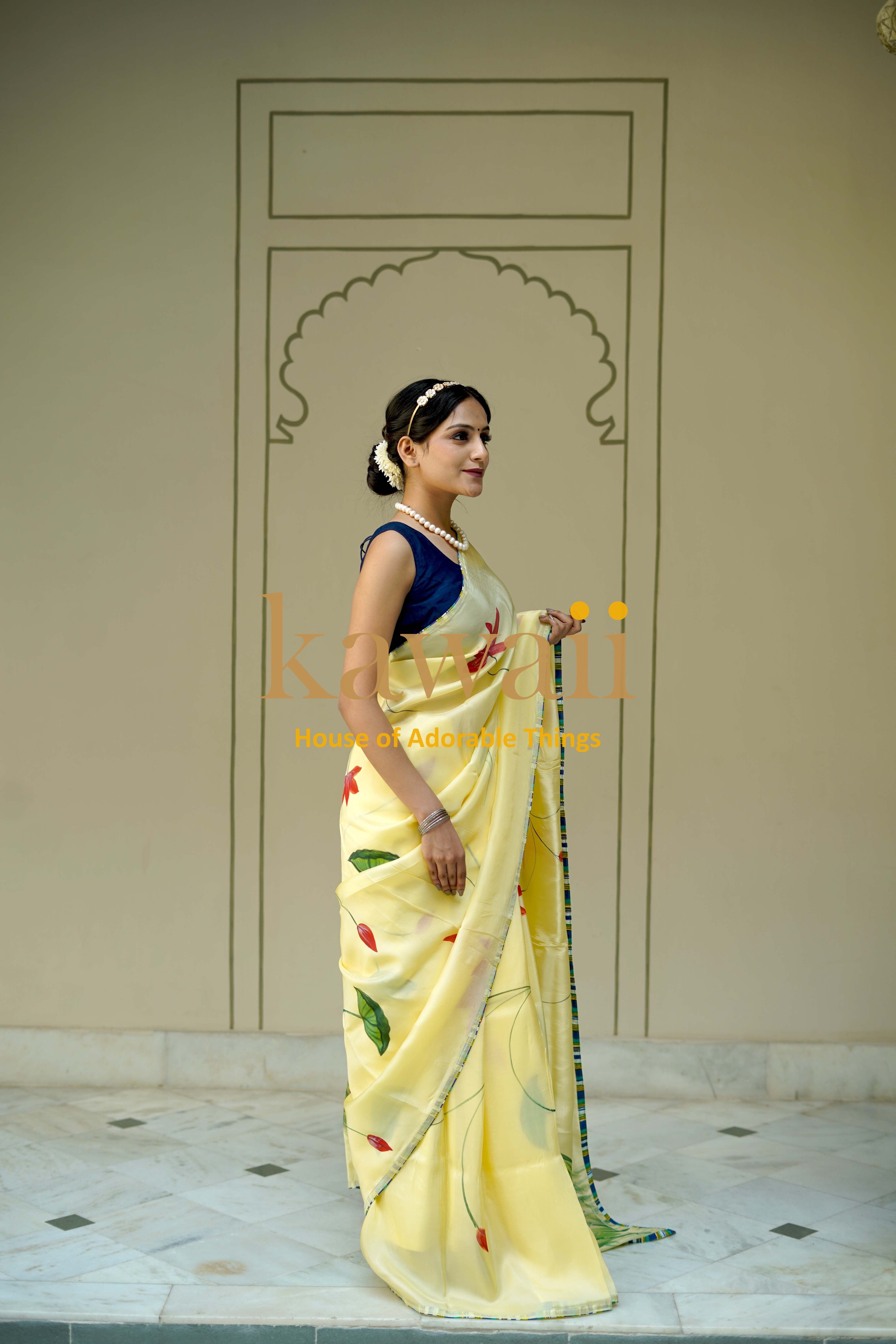 Elegant yellow pichwai saree with colorful floral motifs worn by woman with navy blouse