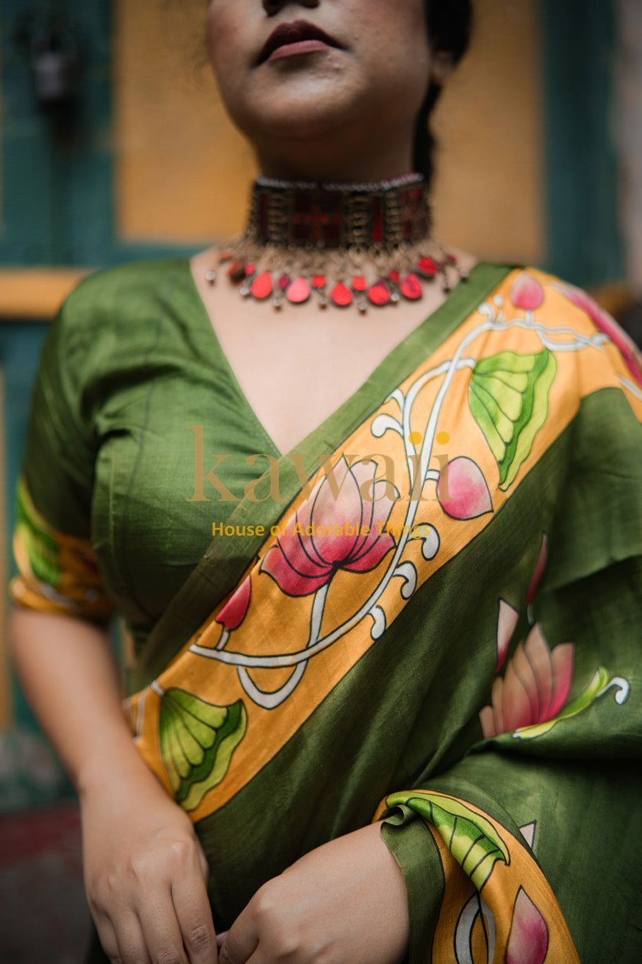 Green and yellow pichwai saree with floral design worn by woman paired with traditional necklace