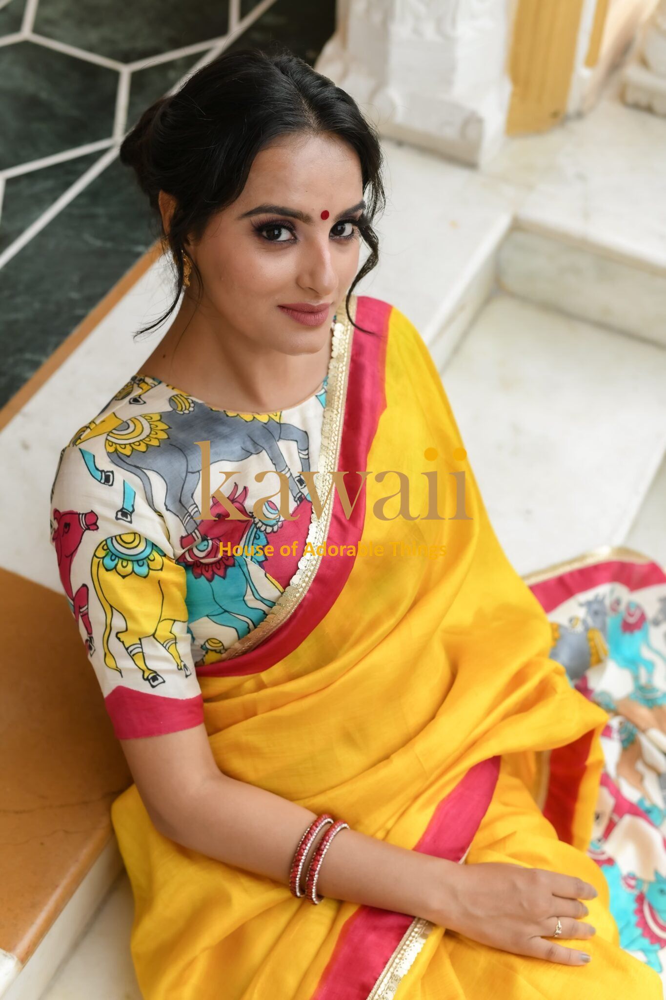Woman wearing a vibrant yellow pichwai saree with detailed multicolor blouse by Kawaii