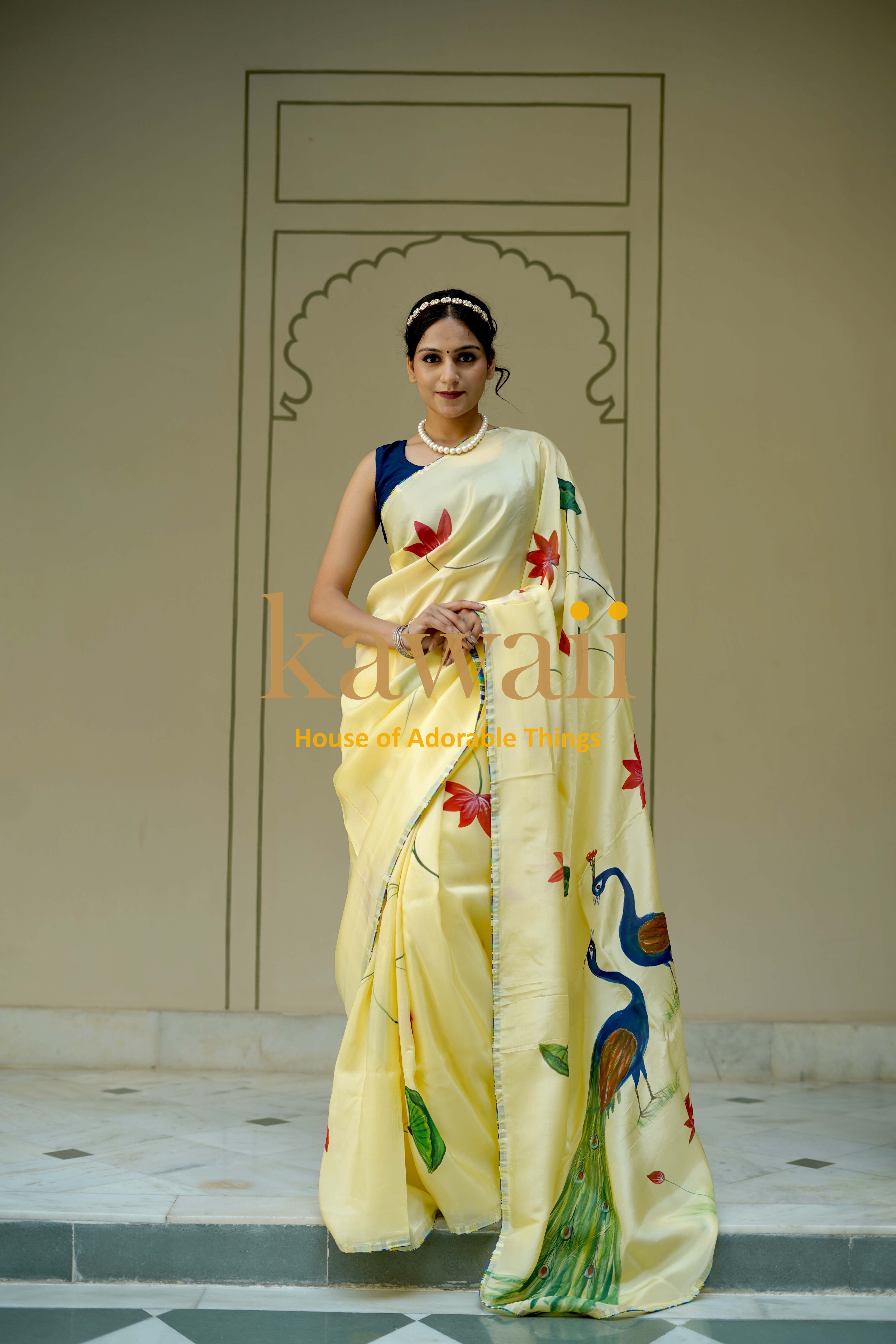 Kawaii pichwai saree in pastel yellow with hand-painted peacock and floral motifs worn by model