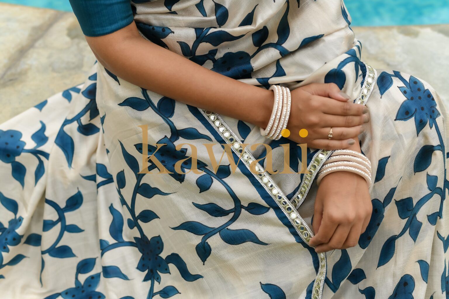 Elegant kalamkari saree in cream with blue floral design, paired with traditional bangles