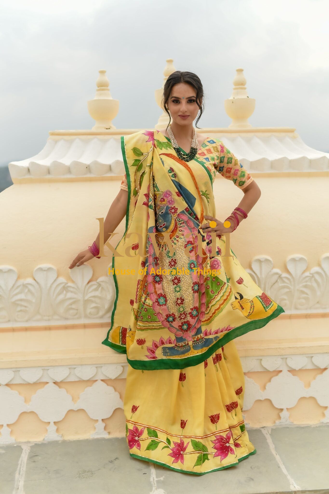 Kawaii yellow pichwai saree featuring traditional intricate floral and bird motifs worn by model outdoors