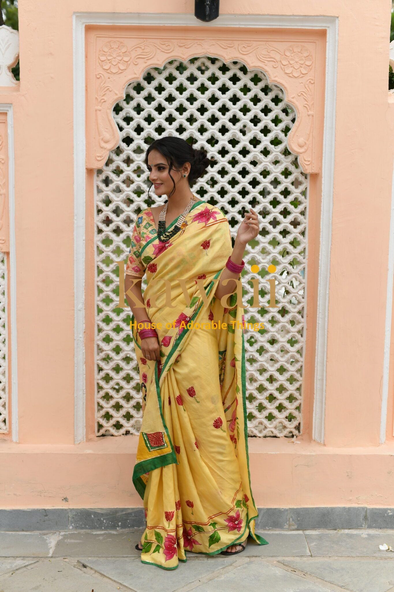 Woman wearing a yellow pichwai saree with floral embroidery by Kawaii, styled with traditional jewelry