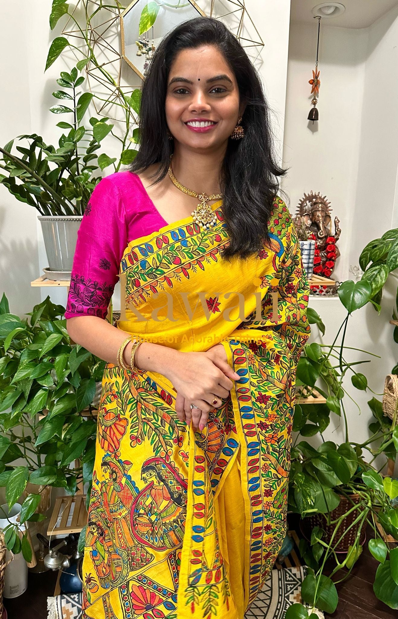 Kawaii madhubani saree in yellow with vibrant traditional art and pink blouse worn by smiling woman