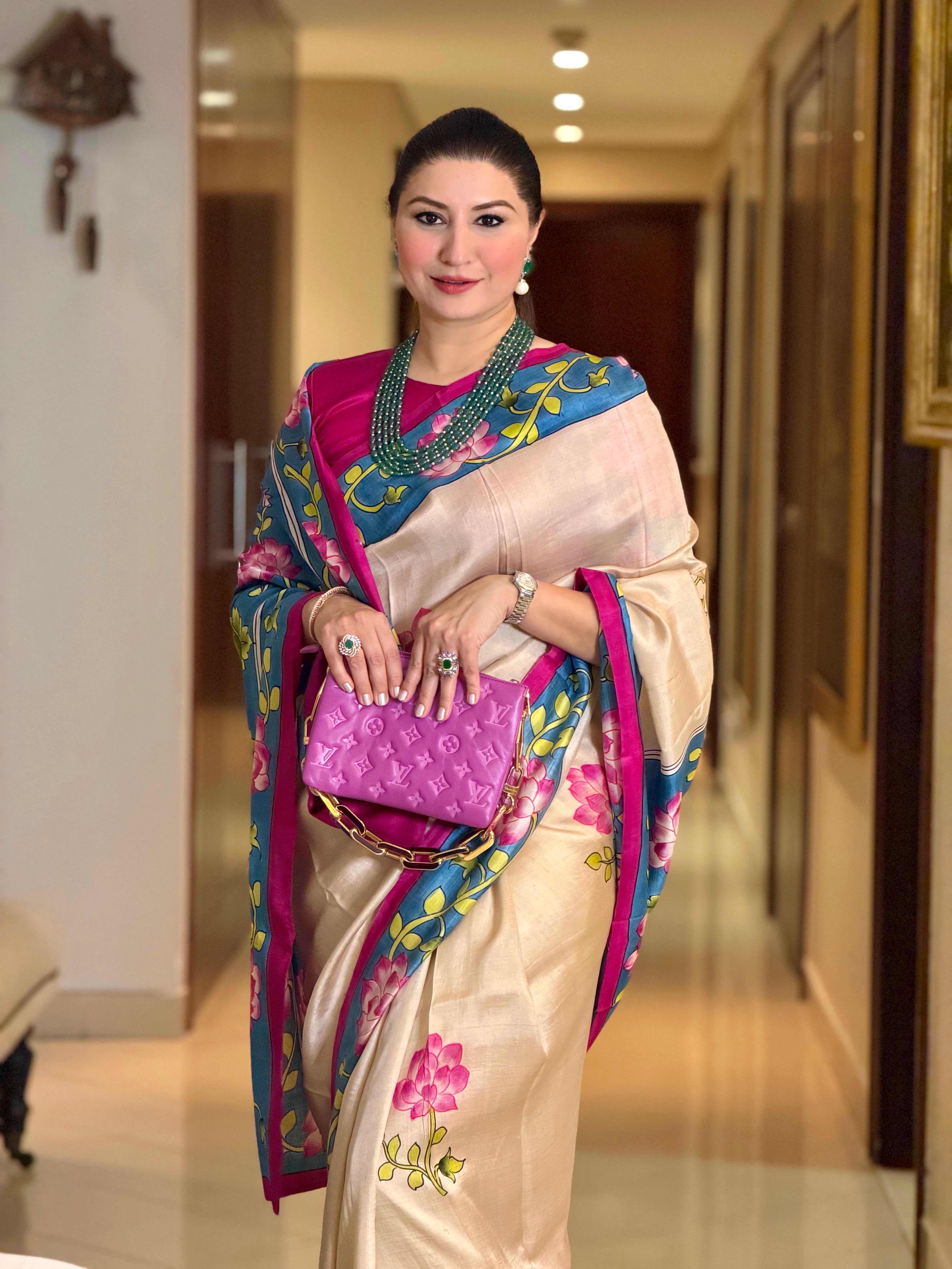 Elegant woman in a Pichwai saree with floral designs, paired with a vibrant blouse and accessories