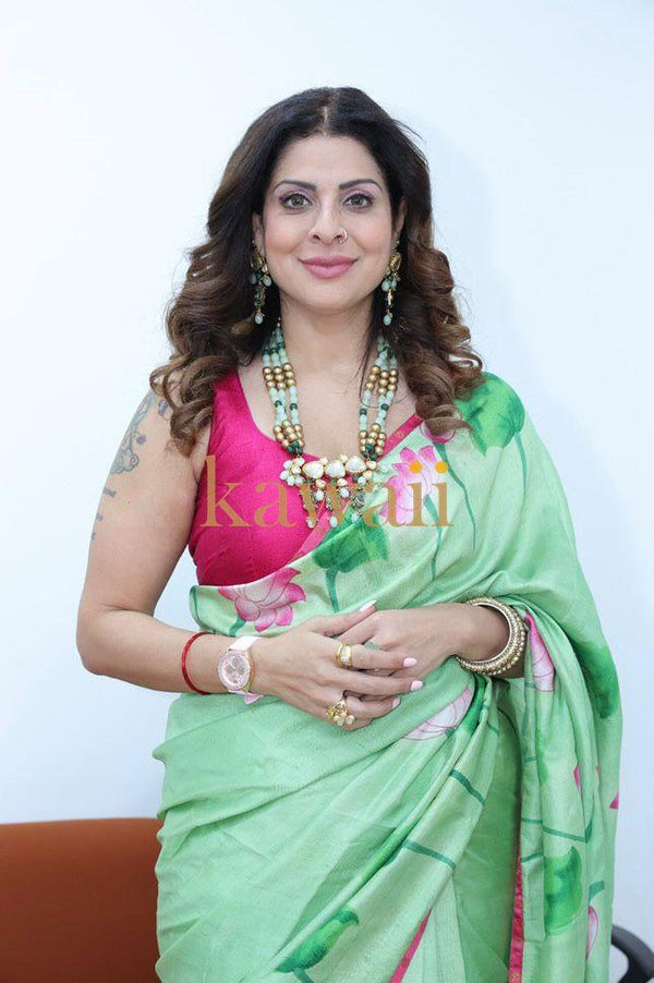 Woman wearing green floral pichwai saree with pink blouse and traditional jewelry