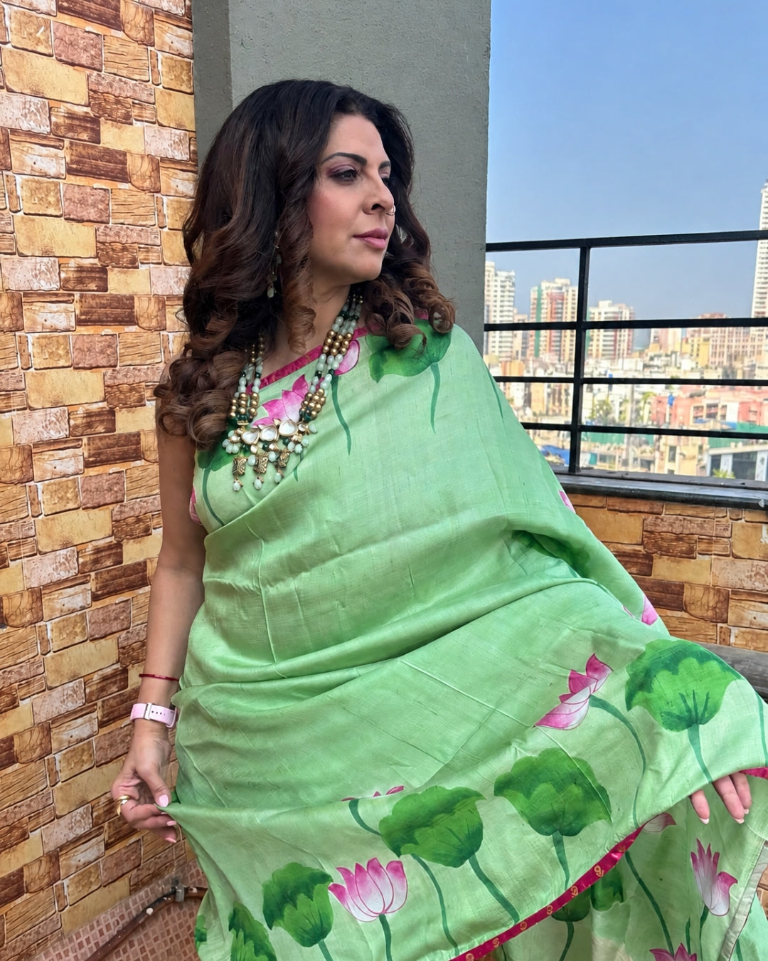 Green Pichwai Saree with Lotus Prints, crafted from lightweight fabric, worn elegantly outdoors