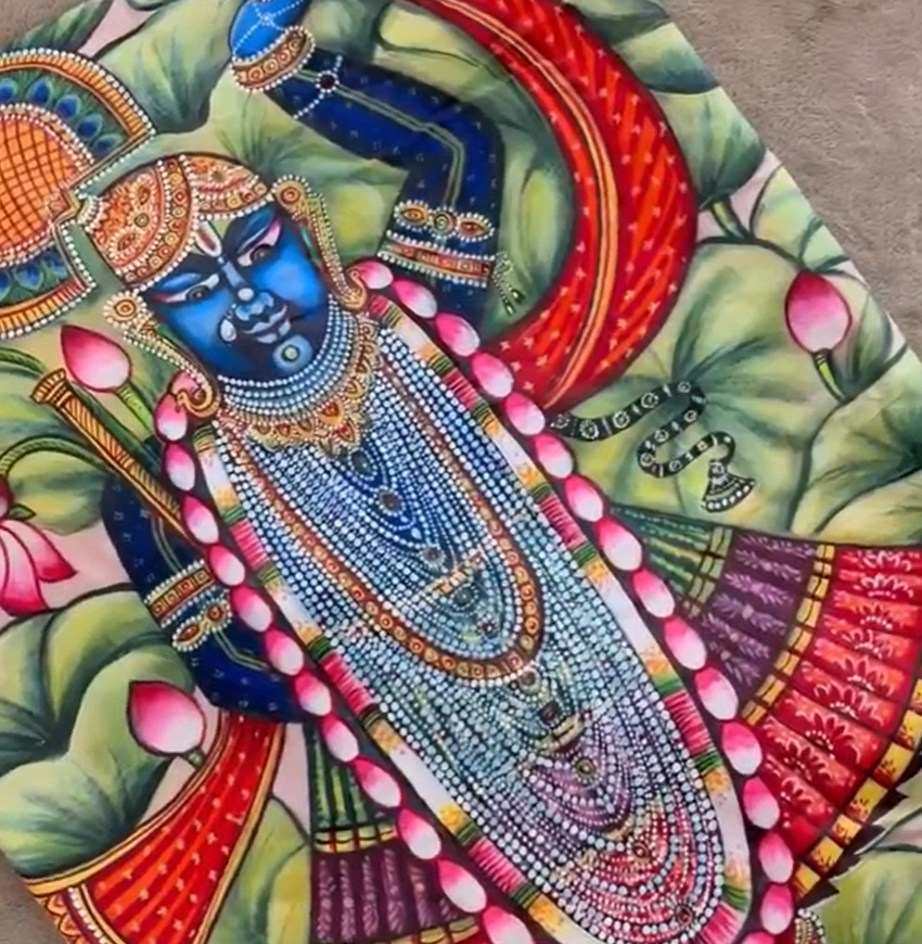 Kawaii pichwai saree featuring intricate traditional artwork of a blue deity adorned with jewelry and surrounded by lotus flowers