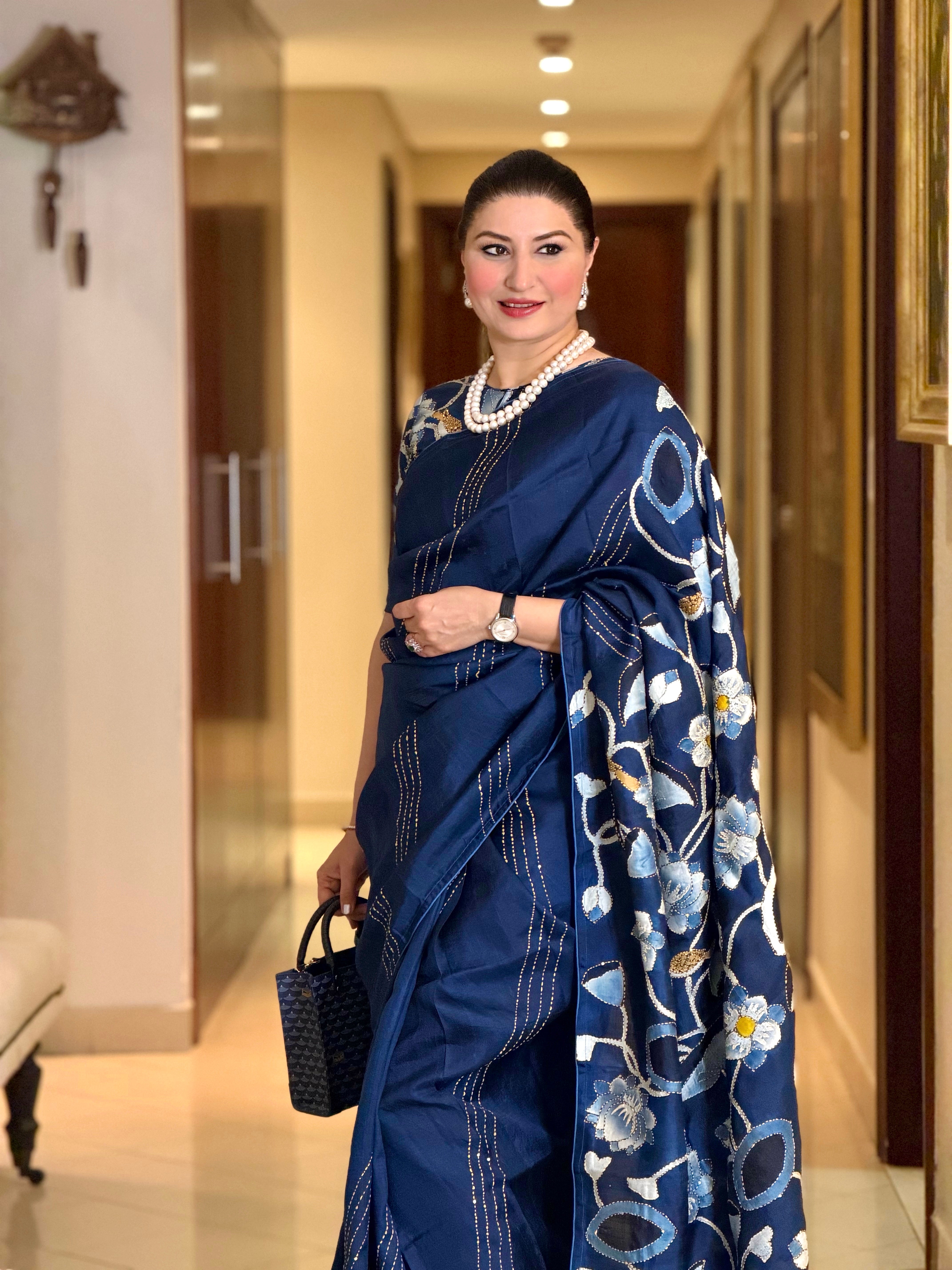 Elegant woman wearing a stunning pichwai saree in navy blue with floral embroidery