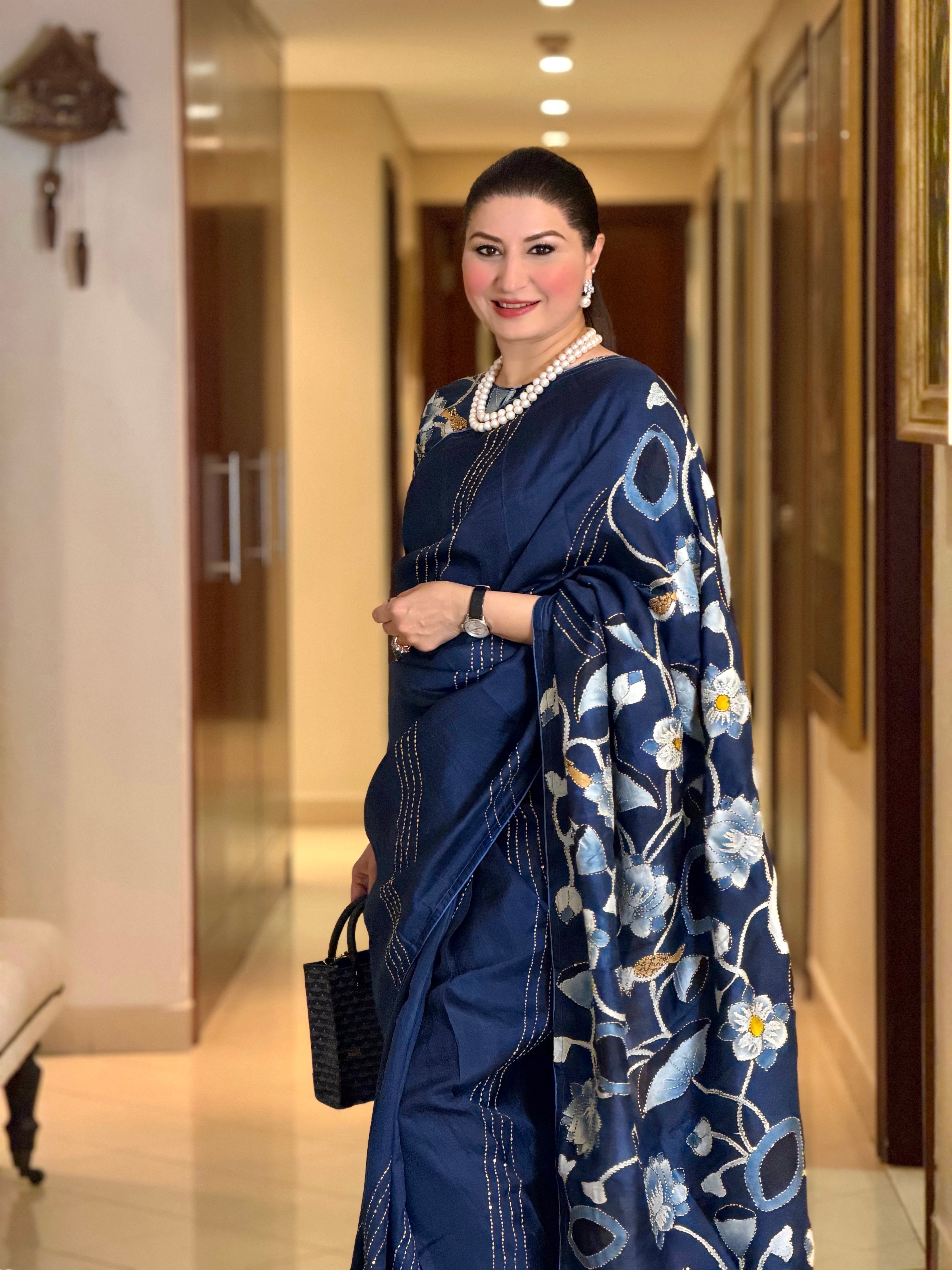 Elegant woman in a navy Pichwai saree with floral embroidery and stylish accessories