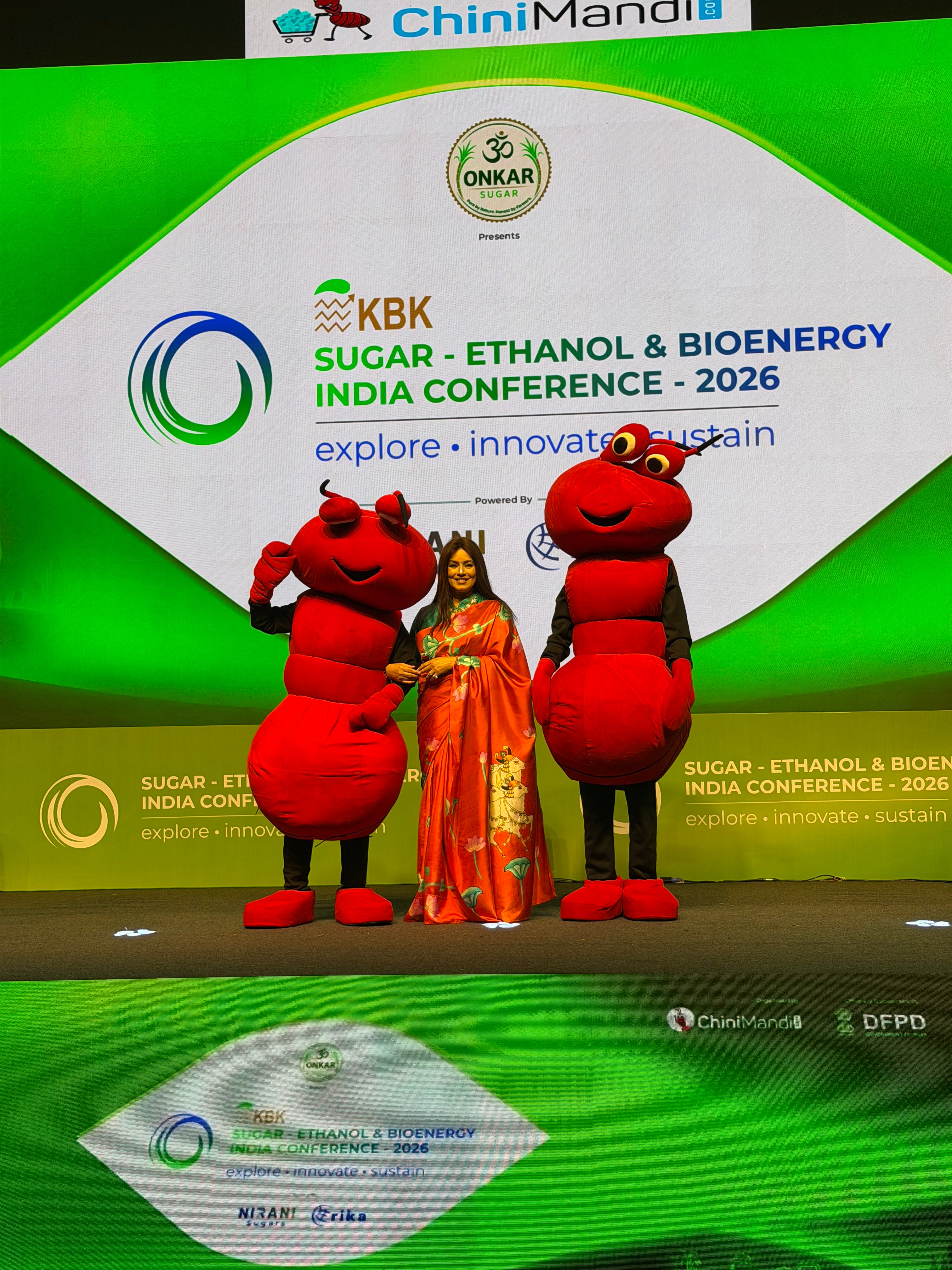 Elegant Pichwai Saree showcased on stage at a conference with colorful decorations