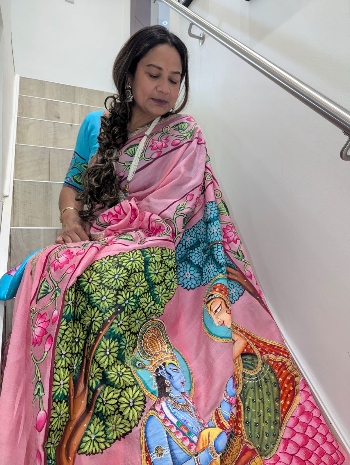 Woman wearing Kawaii brand pink pichwai saree with traditional artistic print and floral motifs