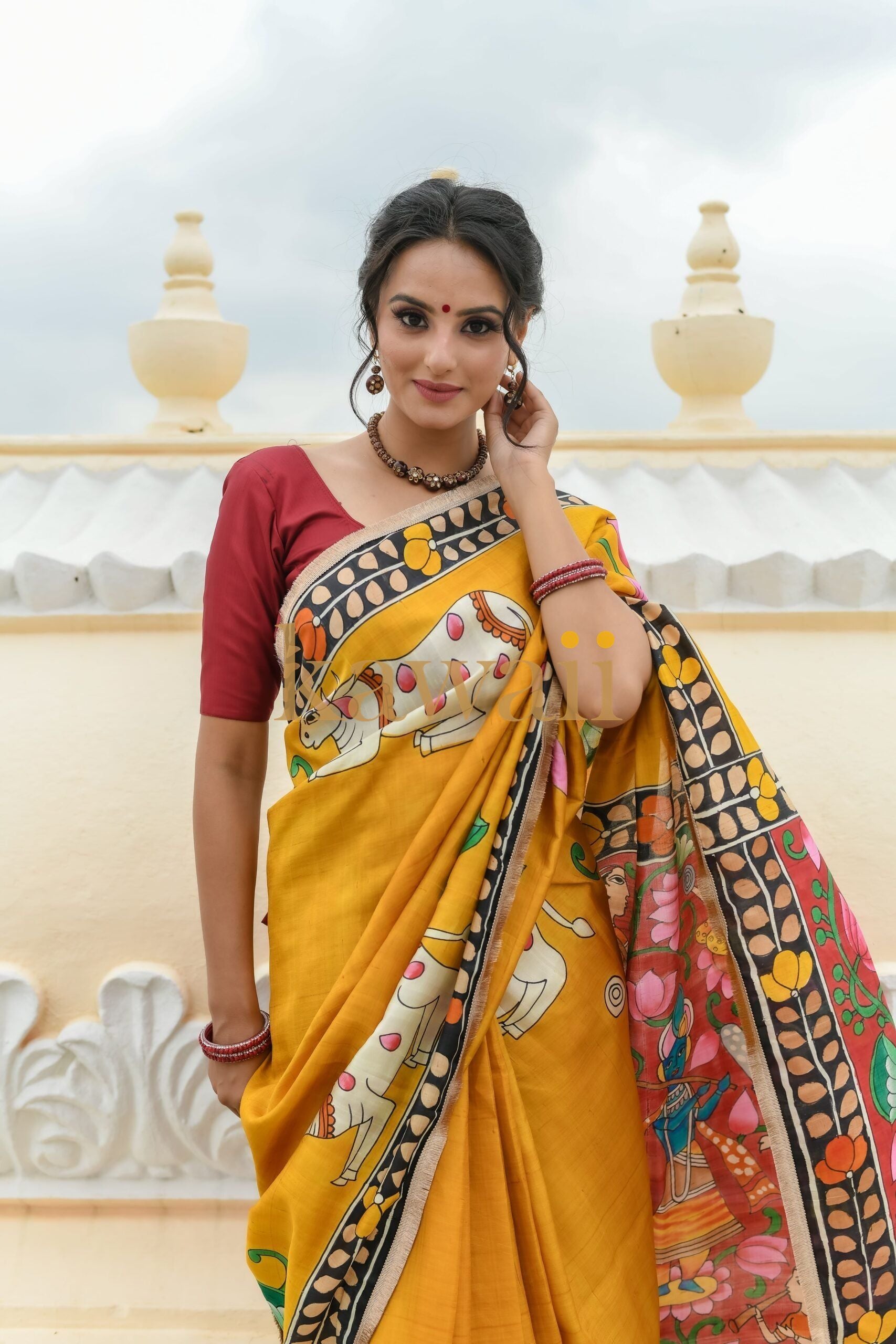 Beautiful pichwai saree in vibrant yellow with intricate hand-painted designs showcasing traditional craftsmanship